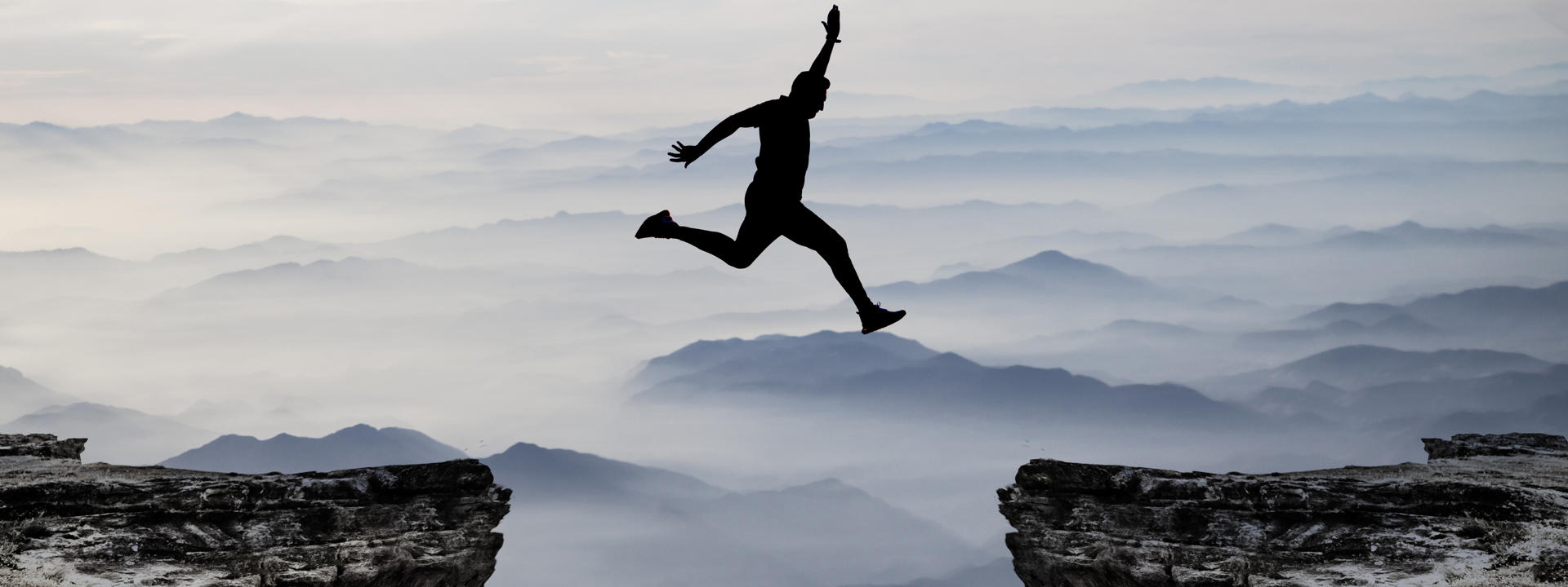 A man jumping between two gaps to illustrate the articles message on Venture debt acting as a bridge between funding stages for tech startups