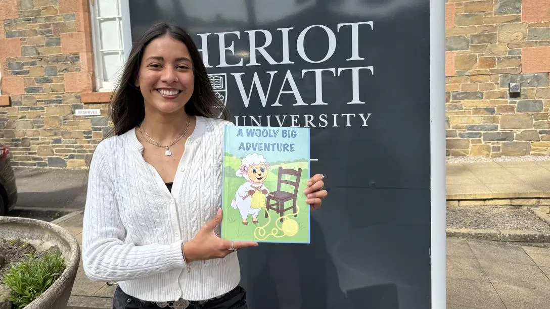 Yennifer Roquett with her children's book about wool.