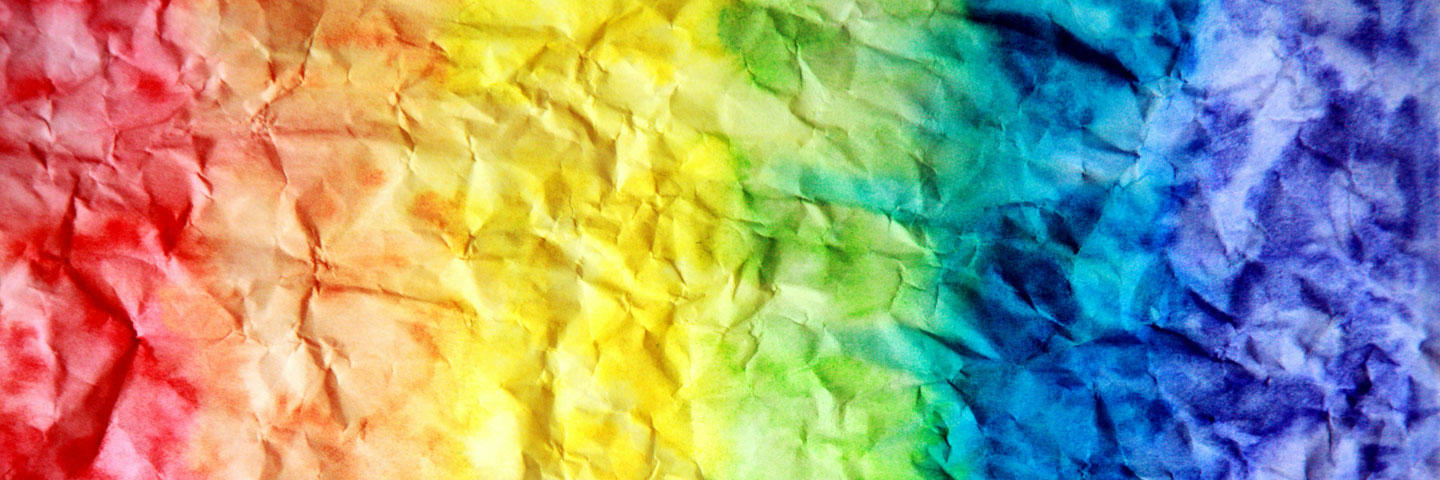 A vibrant, rainbow-colored paper with crumpled edges, displaying a mix of colors in a textured appearance.