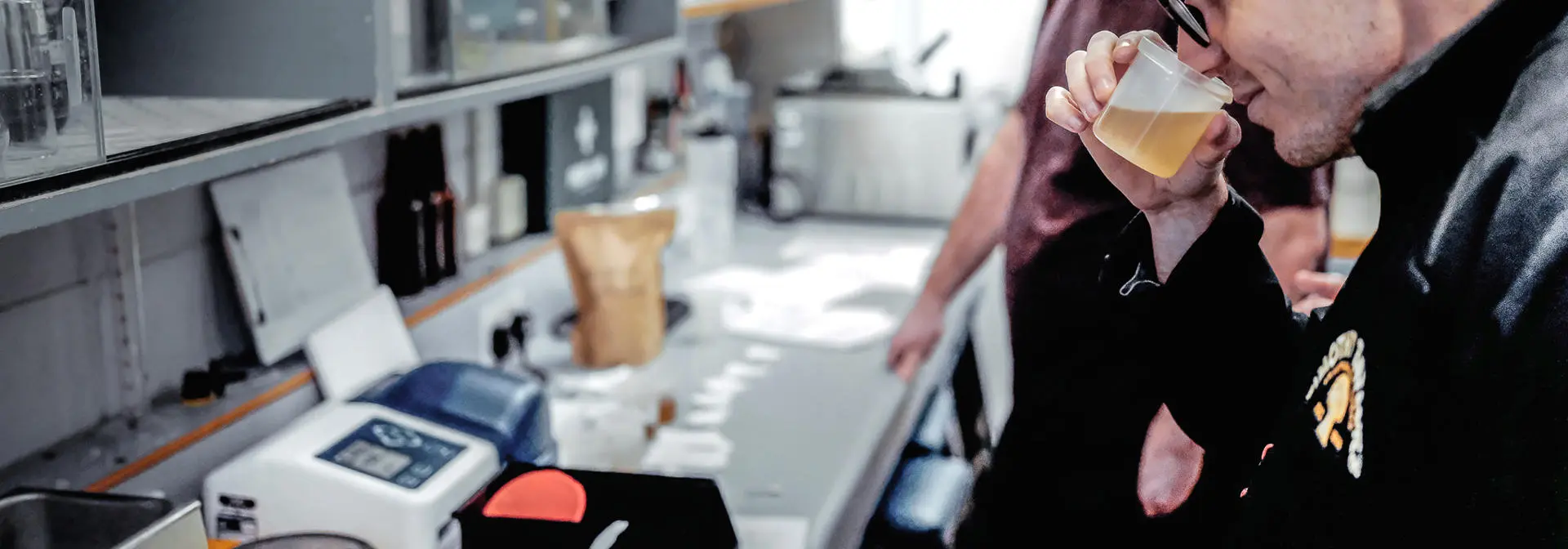 Two male students test smelling a brewing sample