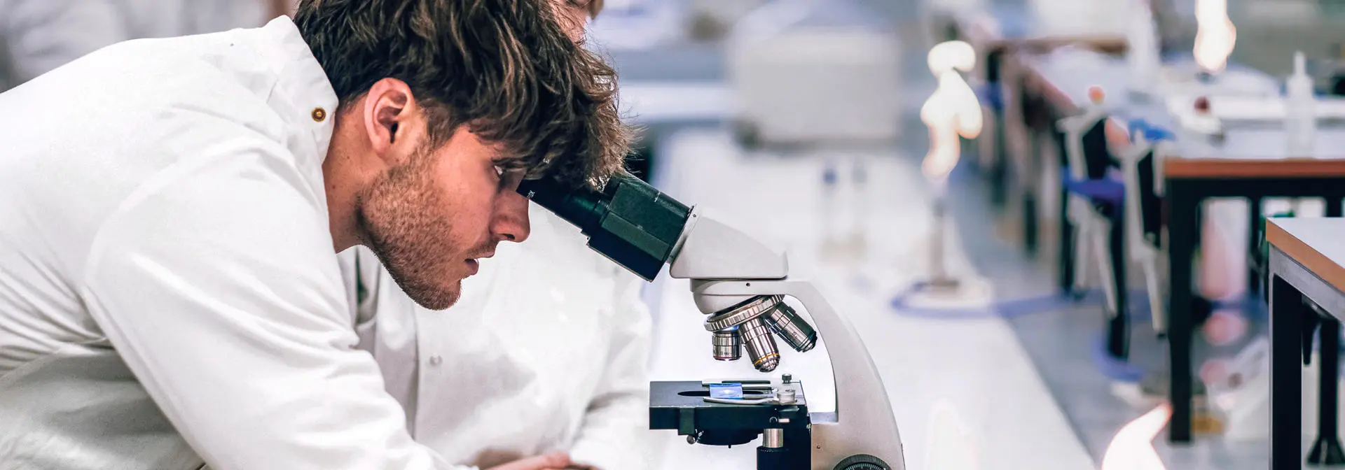 Biology student looking through microscope