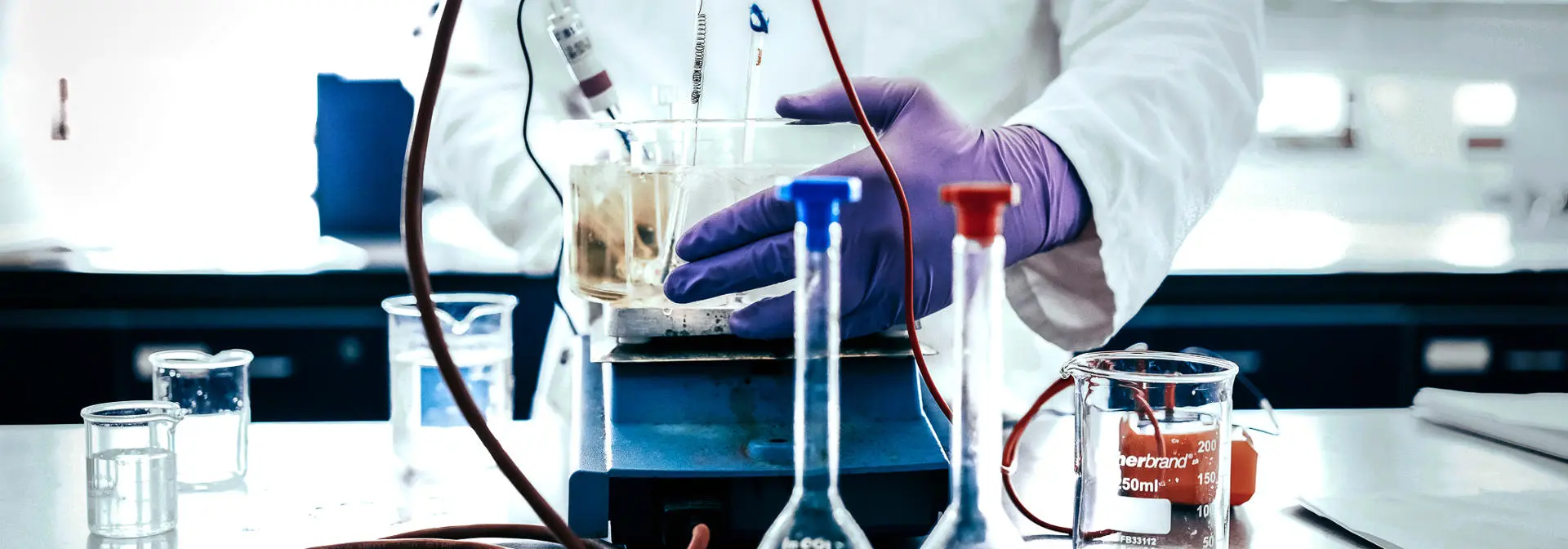 Student with beakers and chemistry apparatus doing an experiment