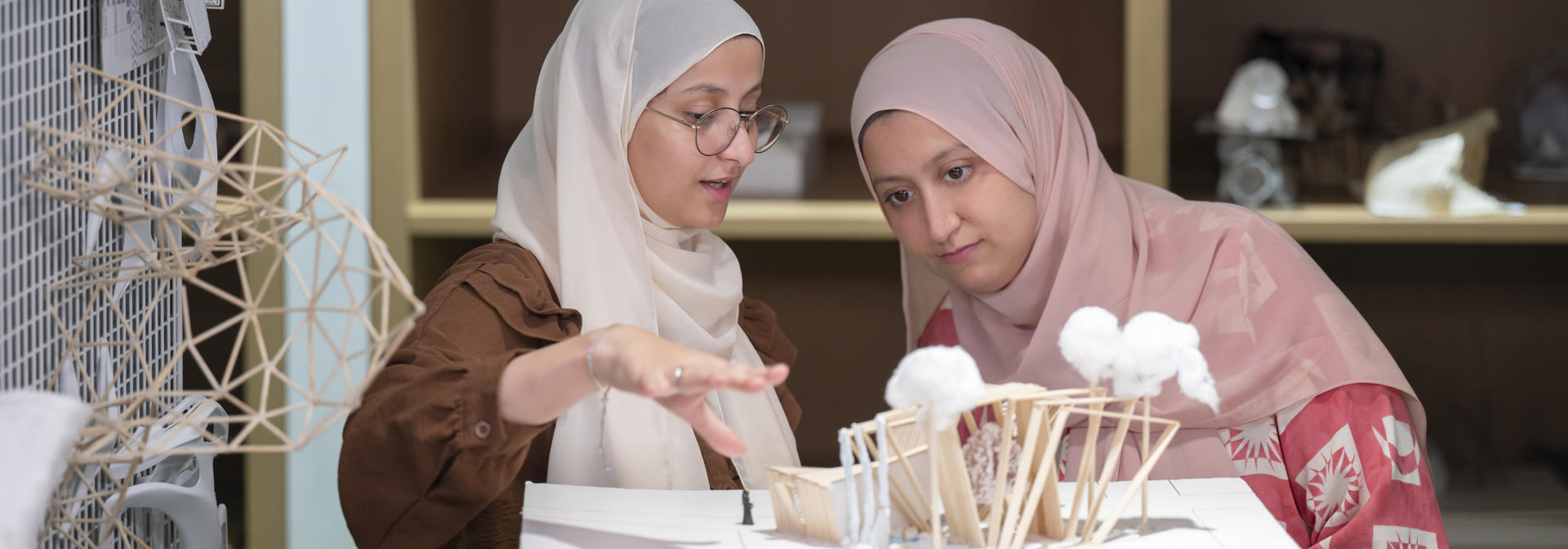 two students examining an architecture model