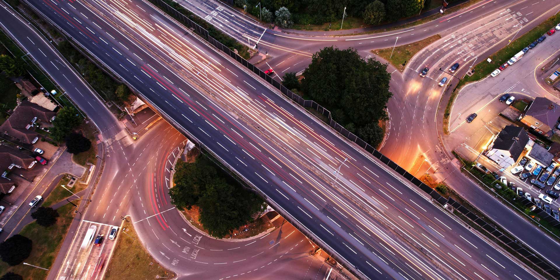 Aerial view of a complex motorway intersection with multiple lanes and vehicles in motion.