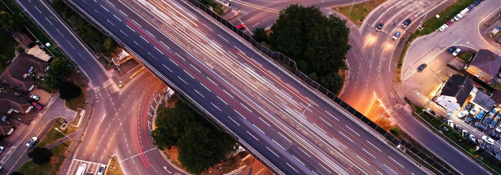 Aerial view of a complex motorway intersection with multiple lanes and vehicles in motion.