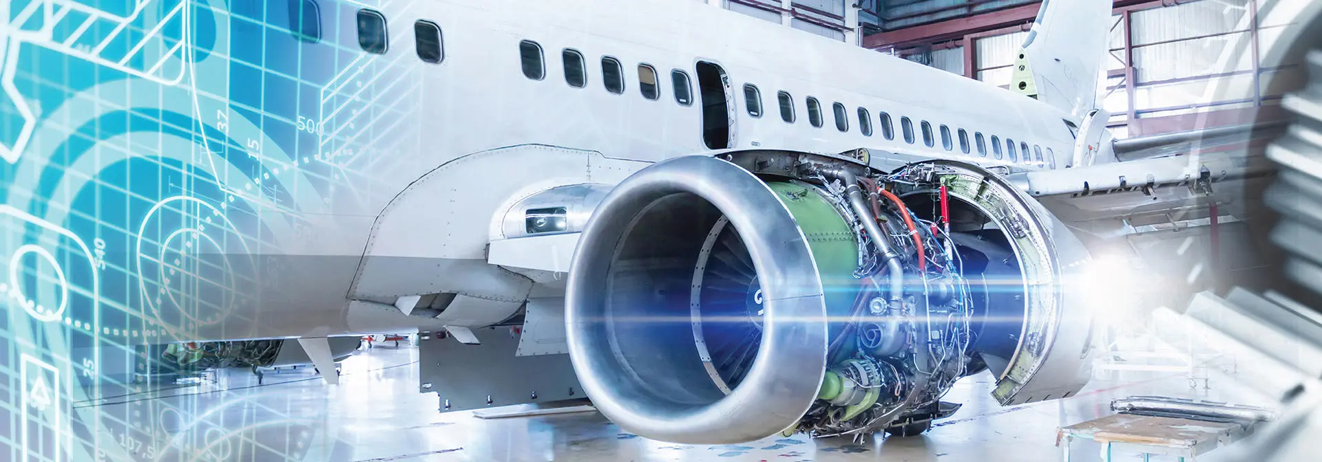 A large airplane engine rests in a well-lit hangar, showcasing its intricate design and engineering.