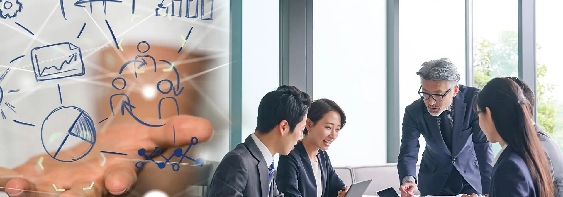 A diverse group of business professionals engaged in discussion around a conference table in a meeting room.