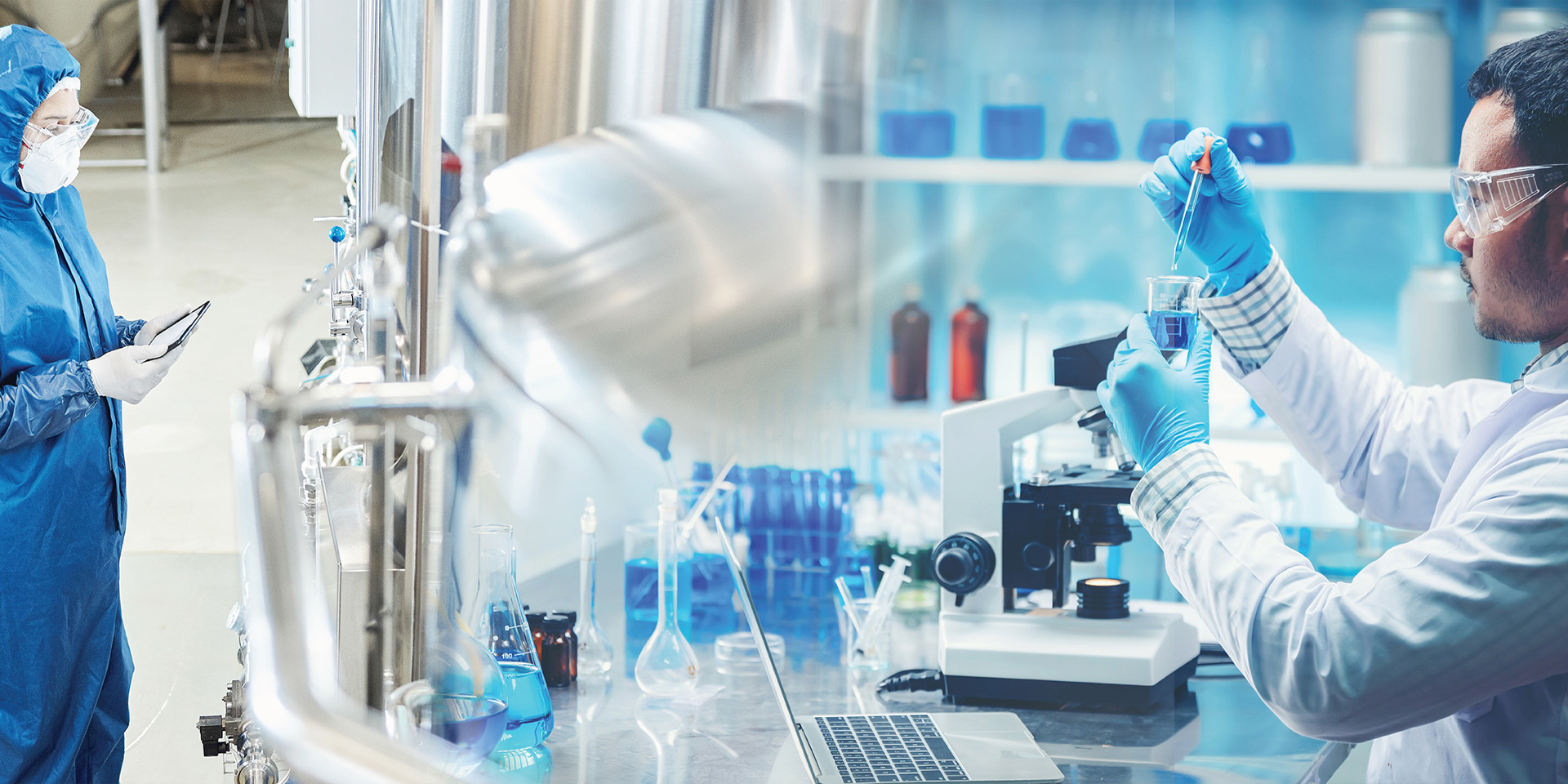 Two individuals in lab coats and gloves collaborate on a scientific project in a laboratory setting.