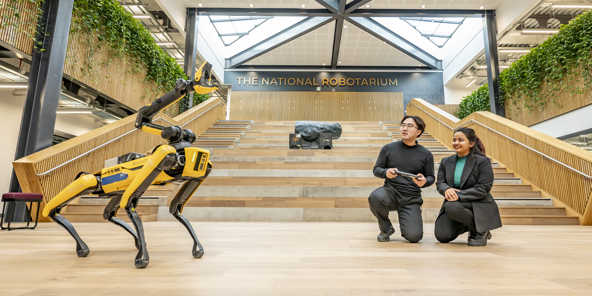 Students controlling a yellow robot dog at The National Robotarium