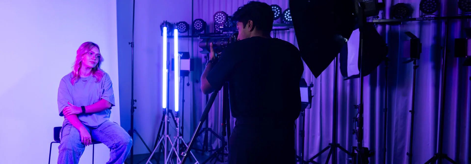 student photographer taking a portrait of model in photography lab
