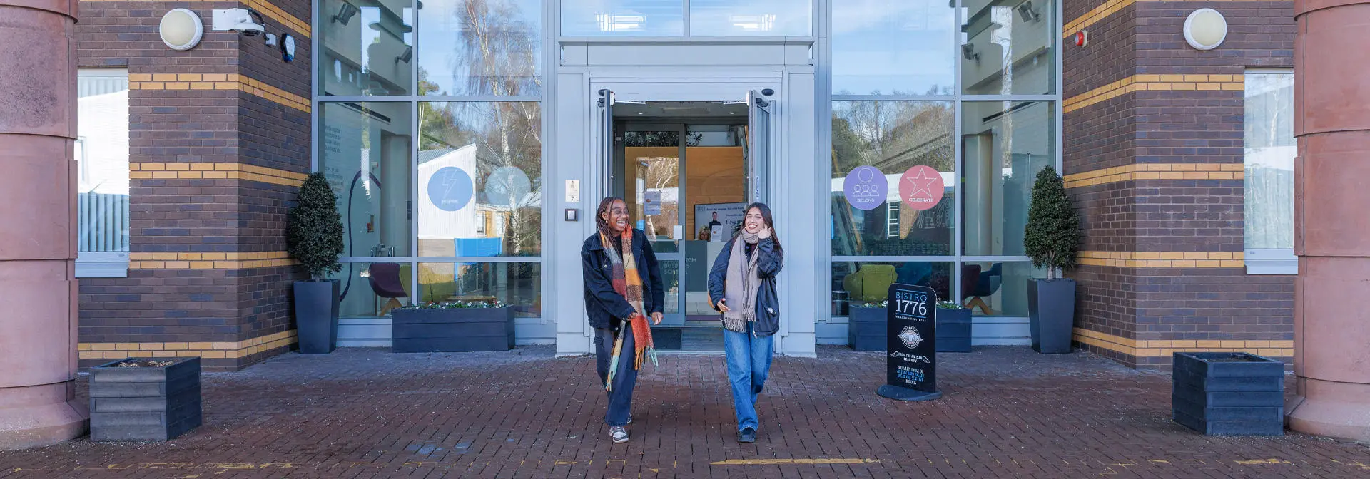 Two students walk outside the modern EBS university building.