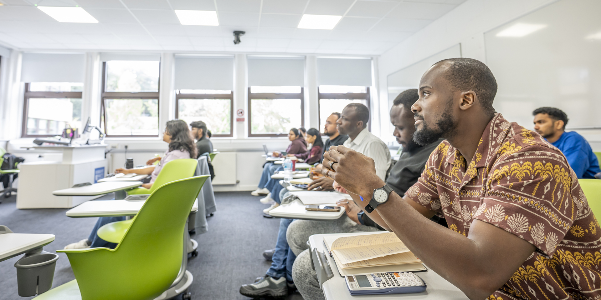 Several students seated in a classroom, focused on their lessons.