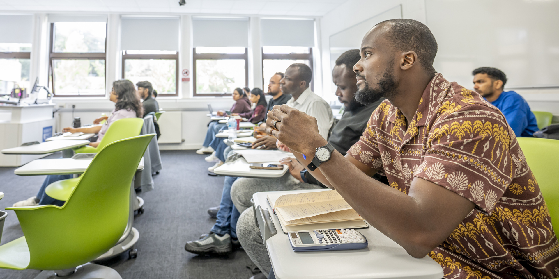 Several students seated in a classroom, focused on their lessons.