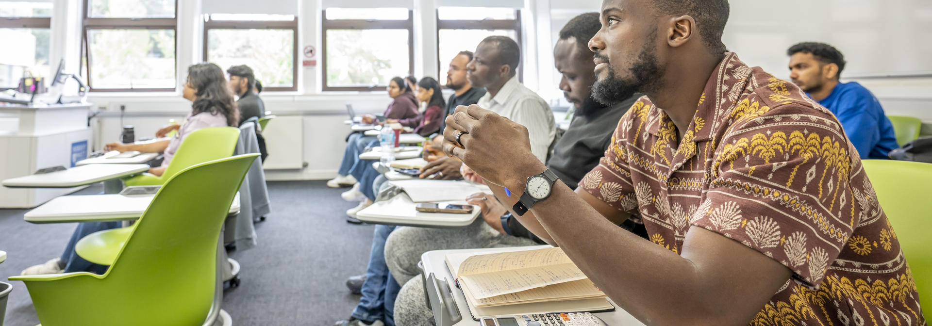 Several students seated in a classroom, focused on their lessons.
