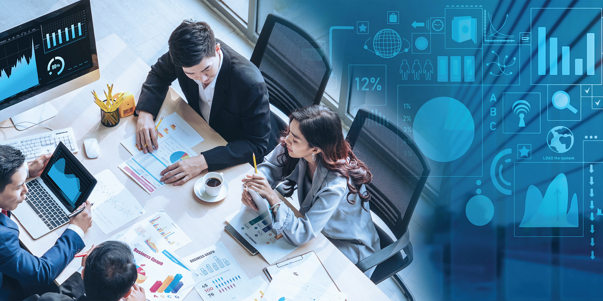 Business professionals collaborating while using computers and tablets in a modern office setting.