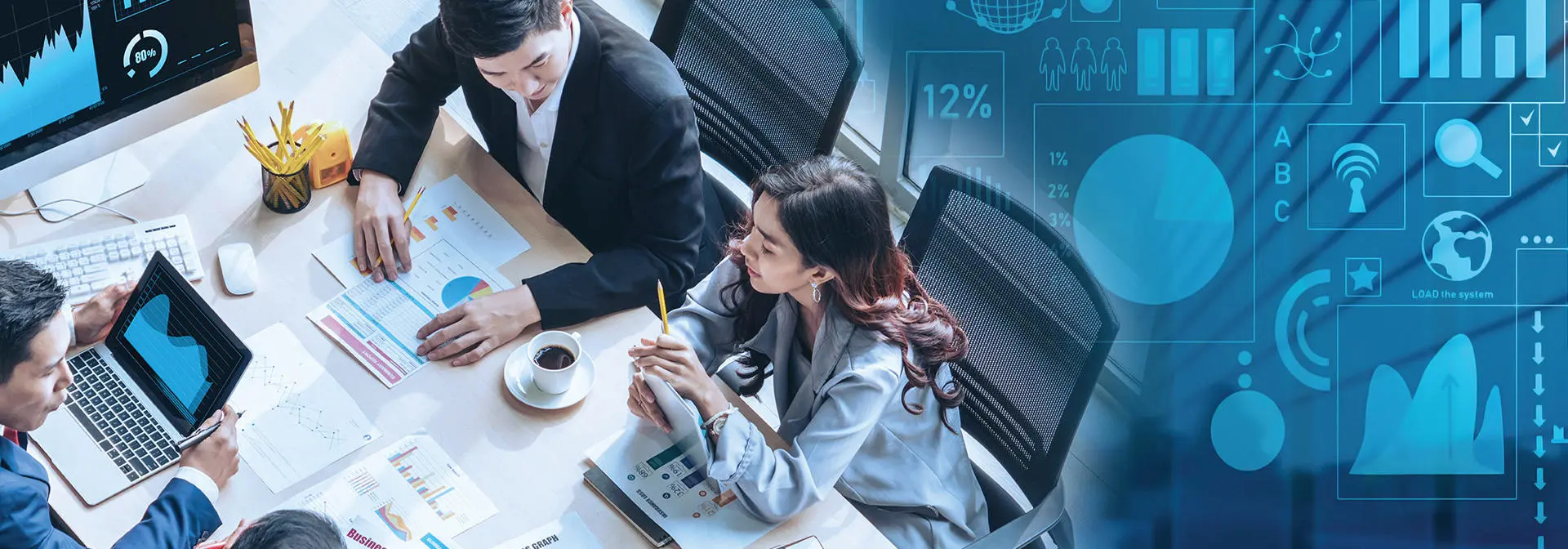 Business professionals collaborating while using computers and tablets in a modern office setting.