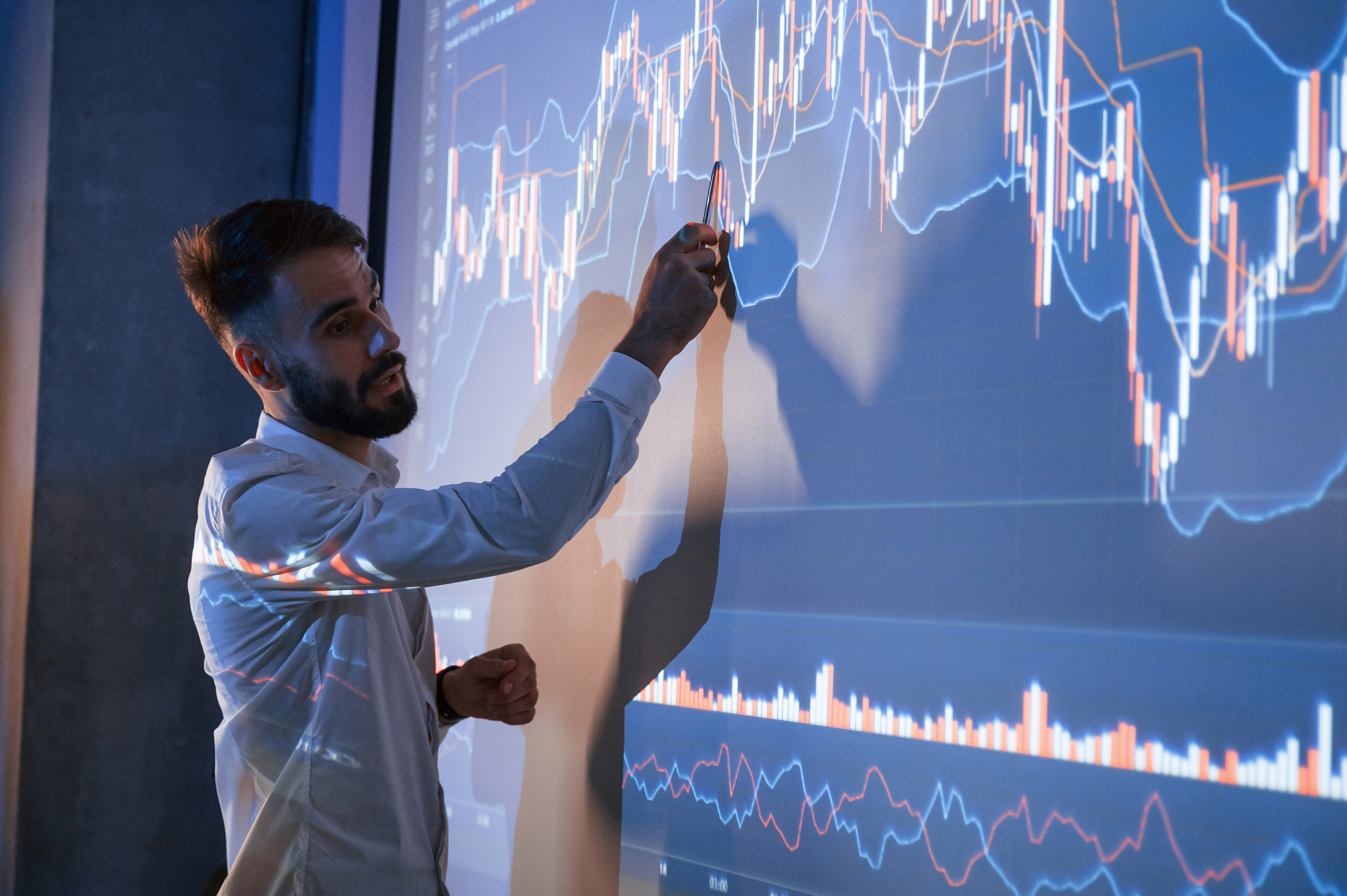 Man presenting chart data on a projection screen
