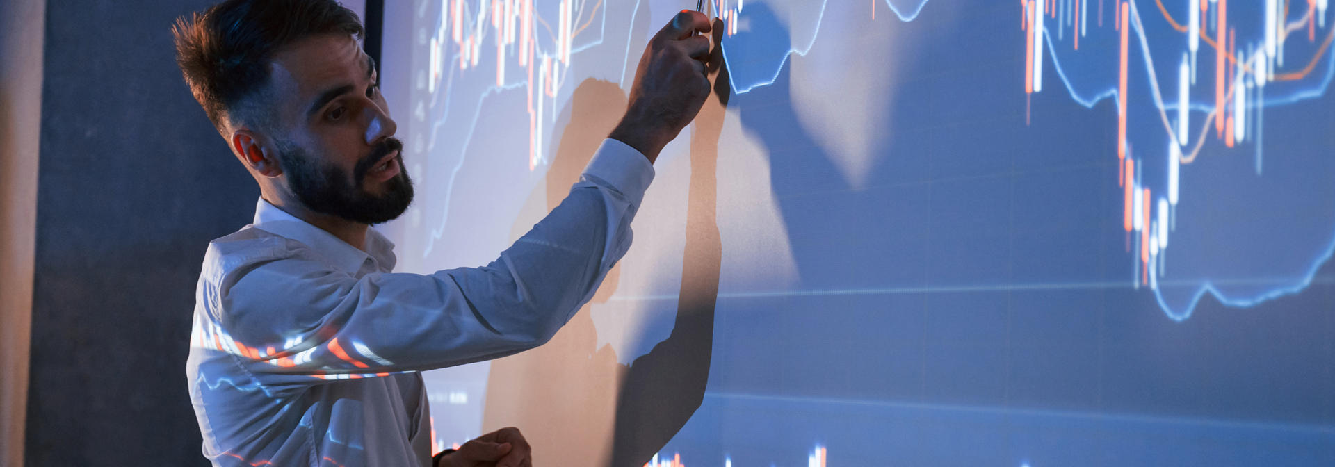 Man presenting chart data on a projection screen
