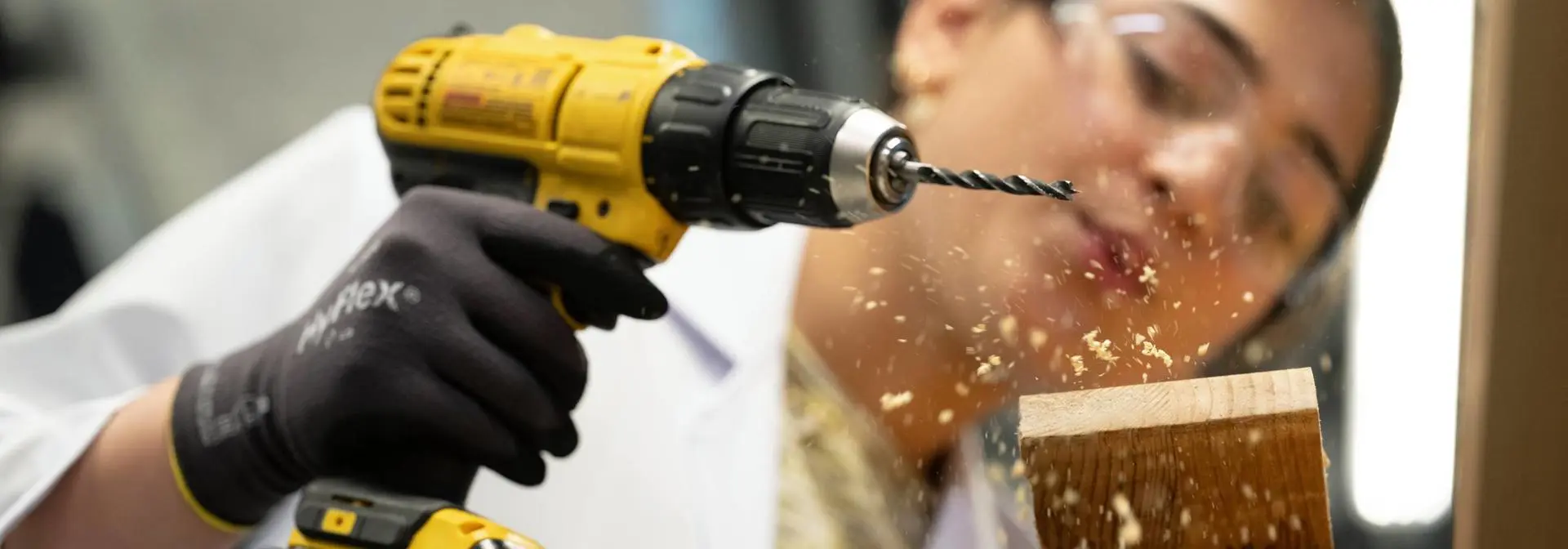 Student in Dubai working with drill and wood