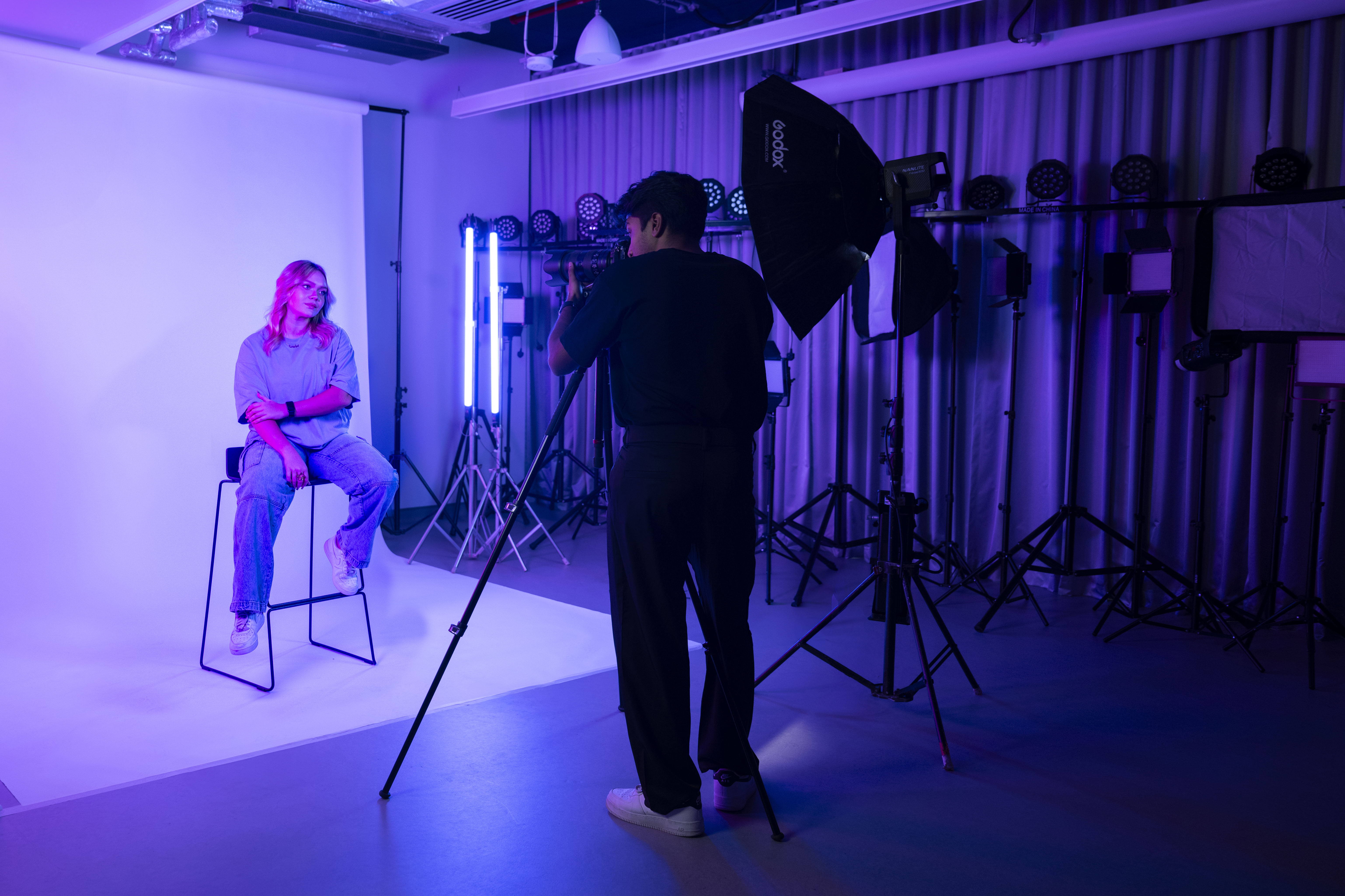 student photographer taking a portrait of model in photography lab