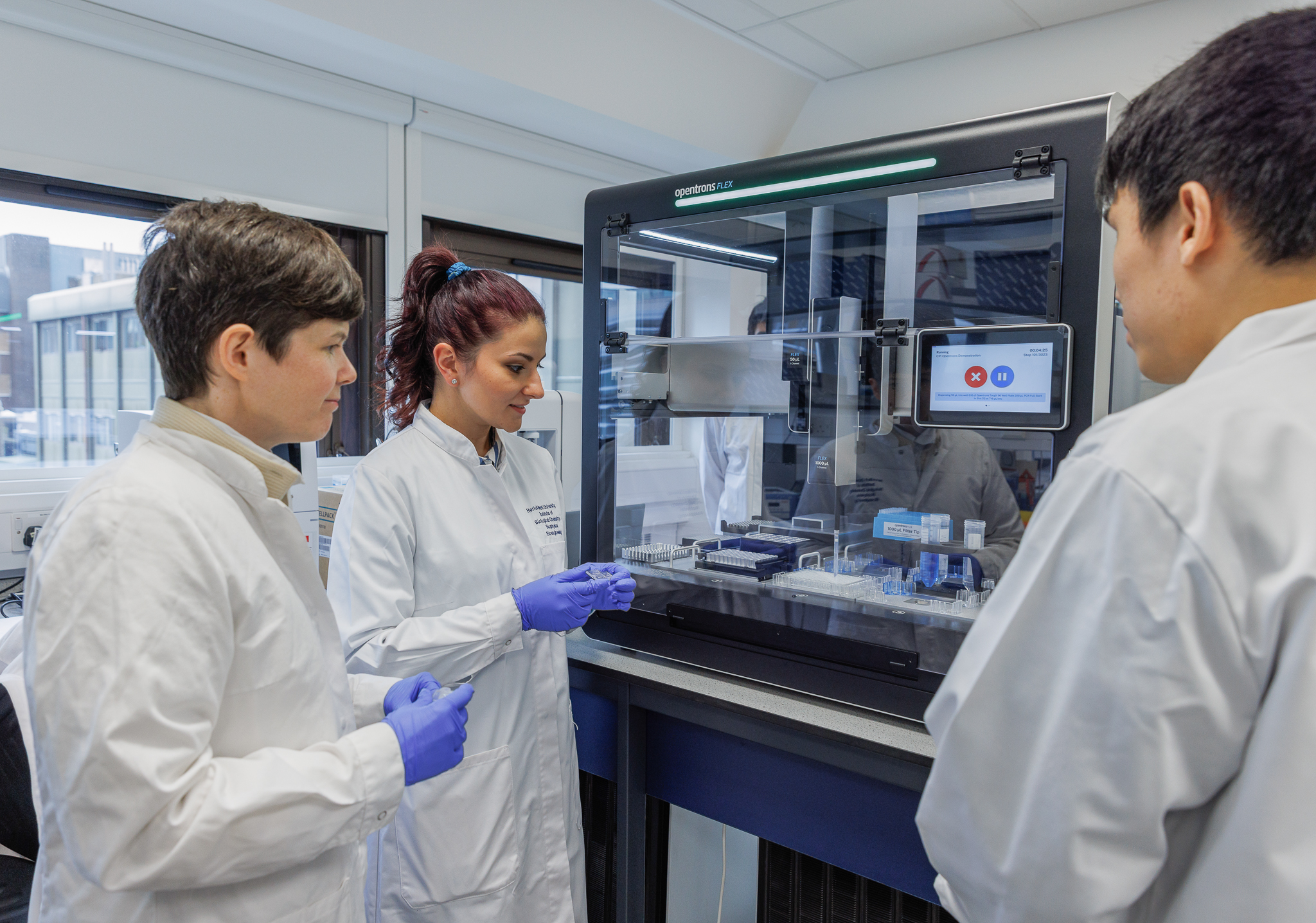 Academic and two students with biomedical engineering machine