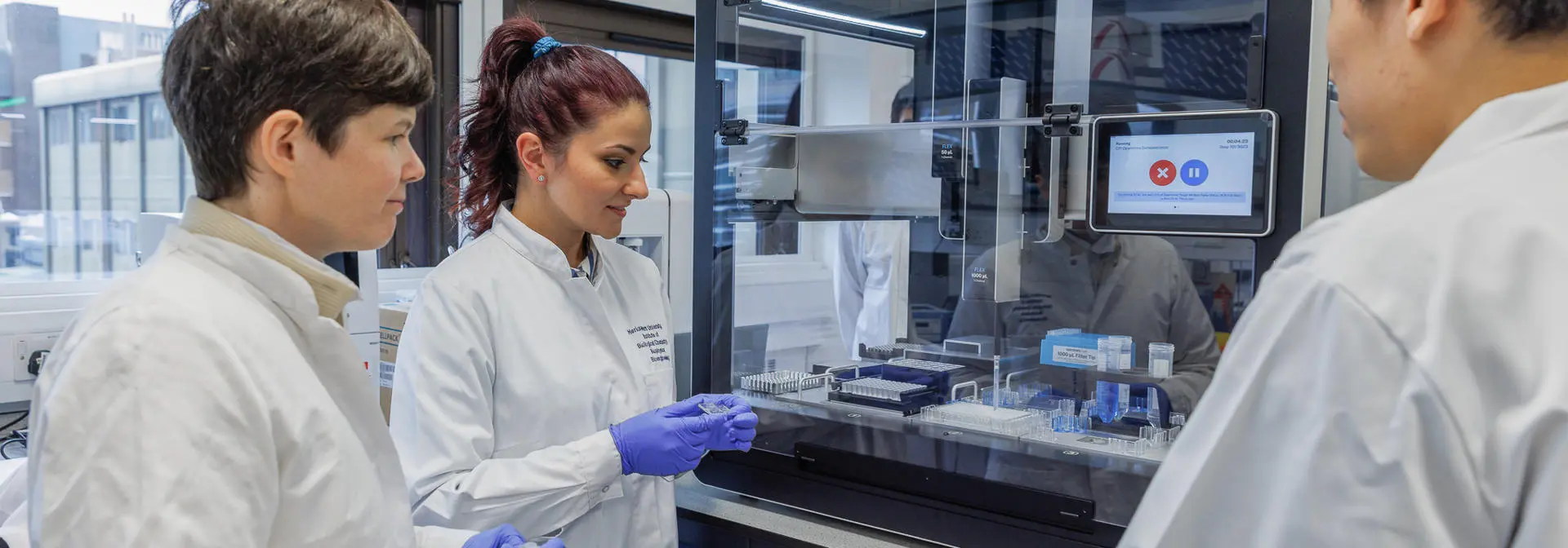 Academic and two students with biomedical engineering machine