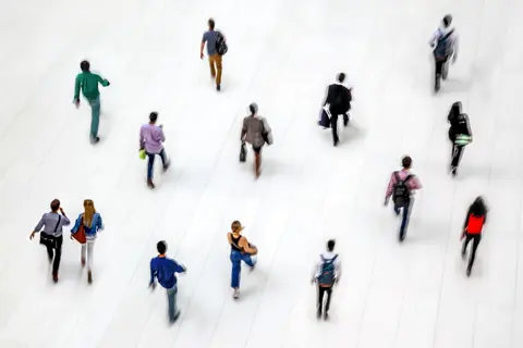 People walking in a white-tiled hall