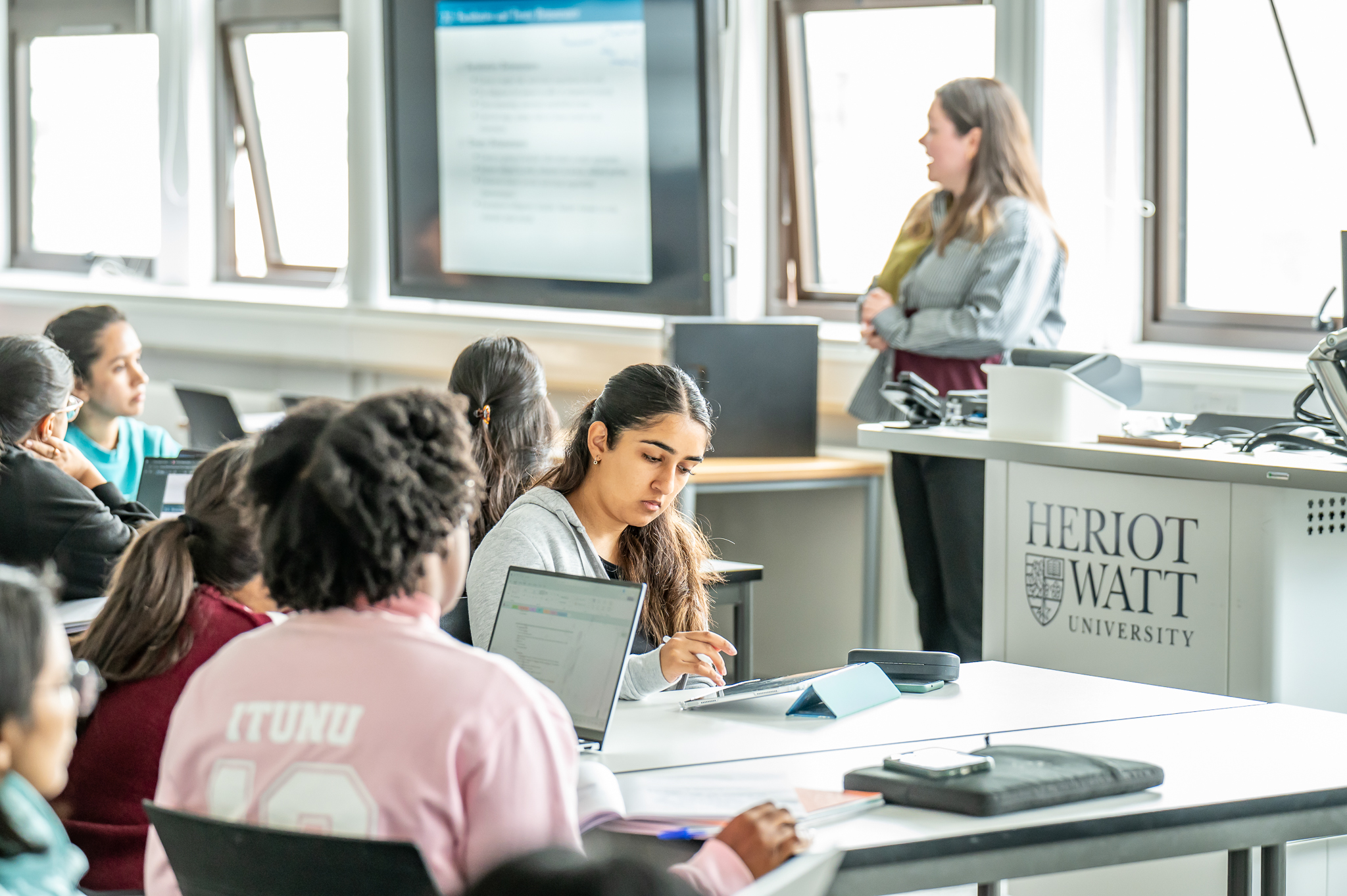 Professor talks to students in a classroom 