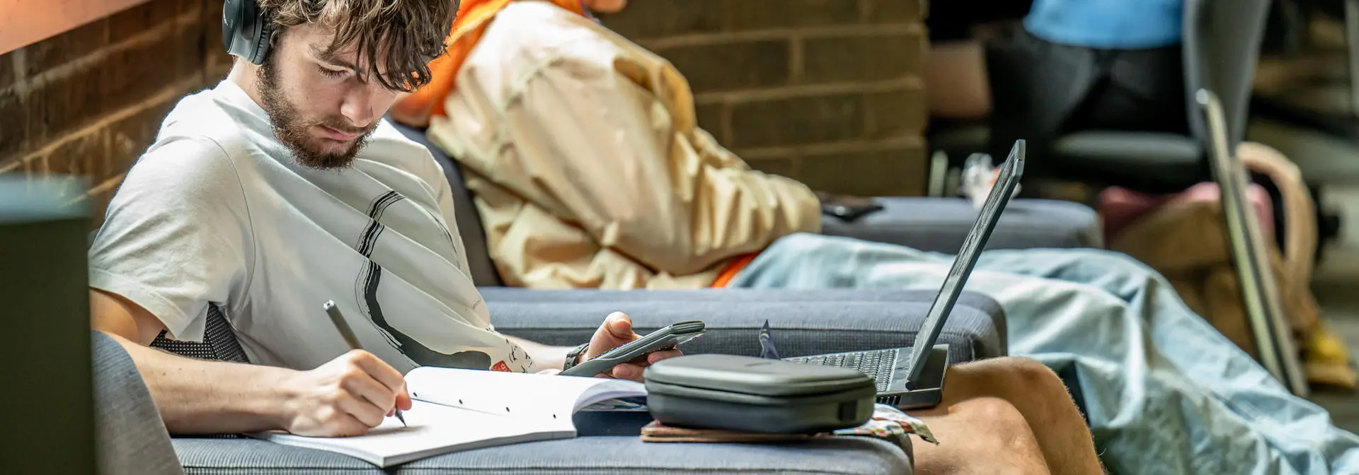 Students sitting down and working in a common area