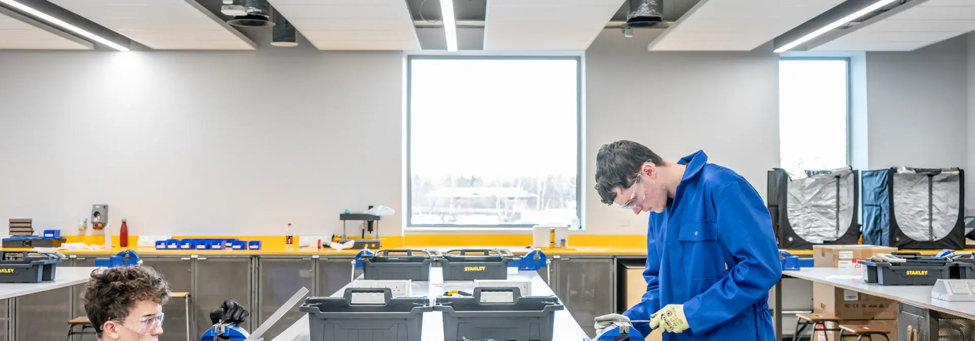 Two students using a lathe in GRID