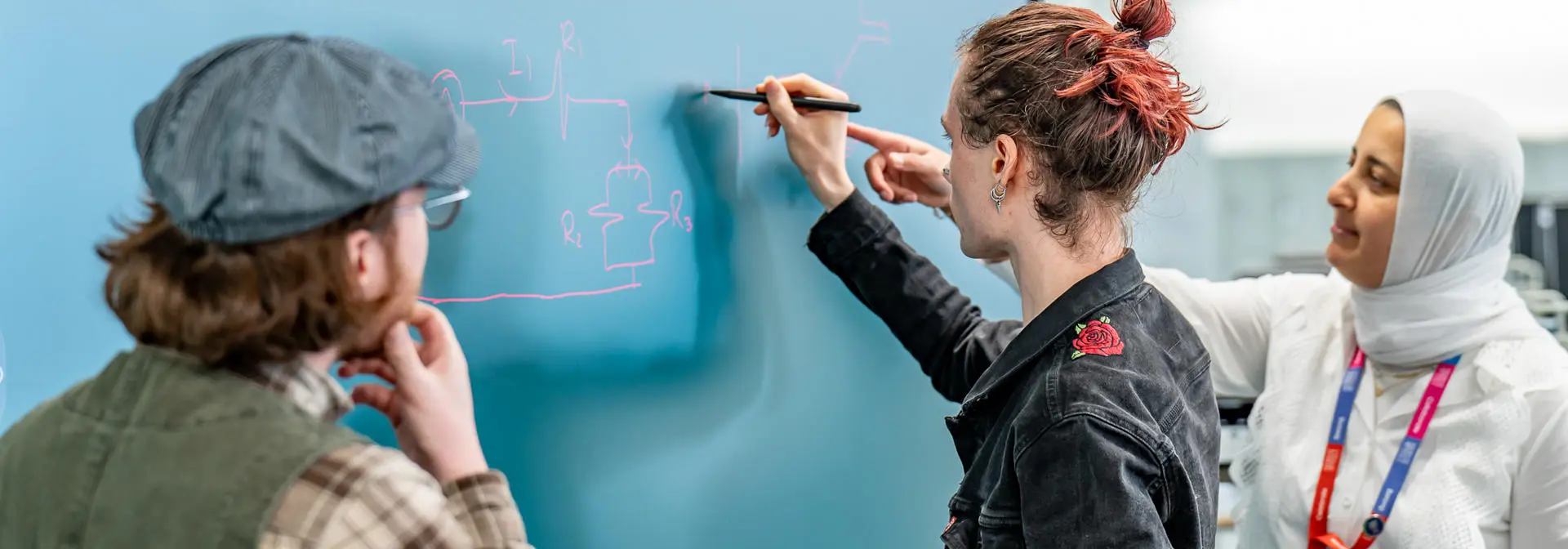 Lecturers writing on a digital blackboard for students
