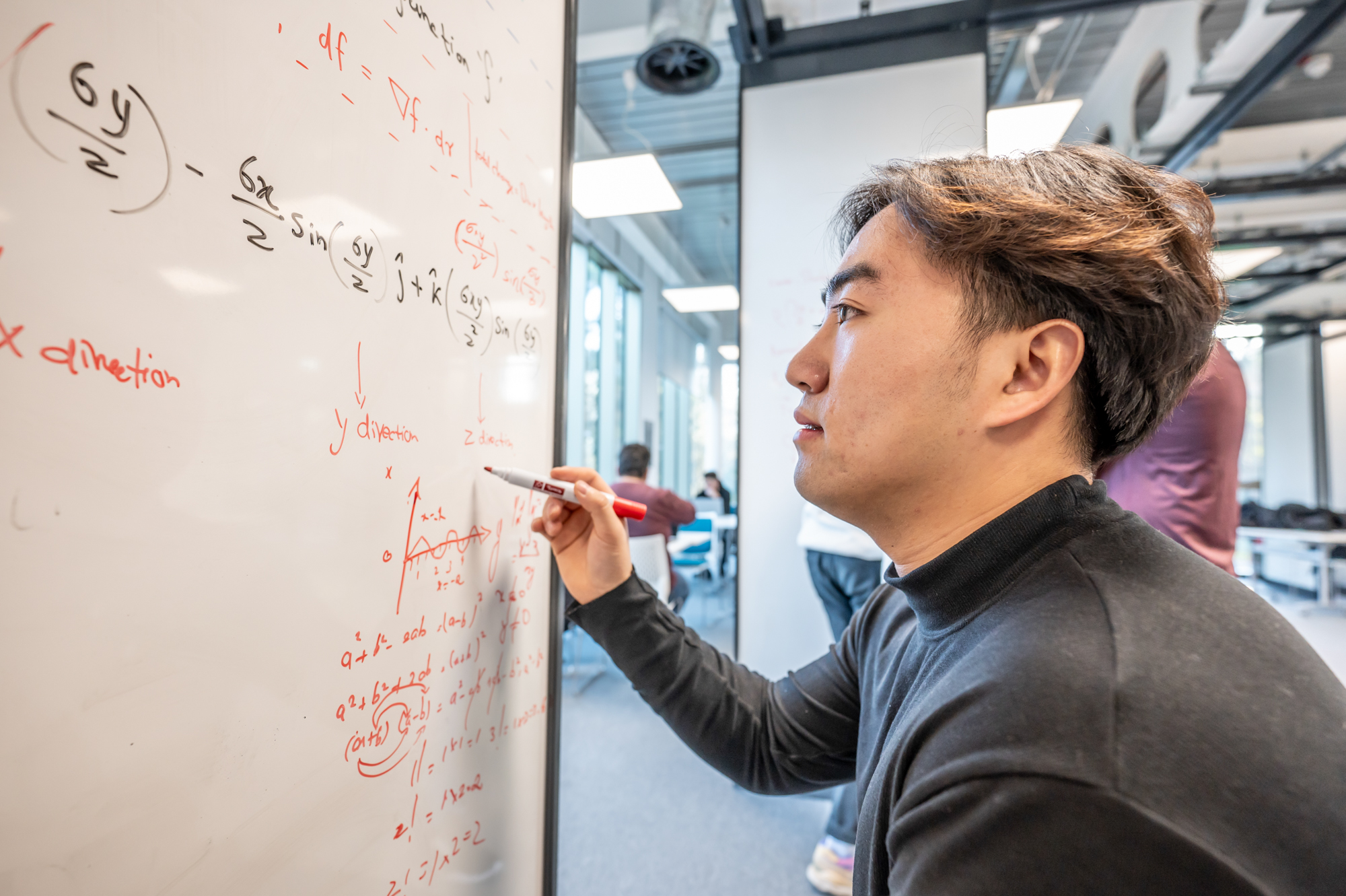 Student working on a maths problem on a whiteboard