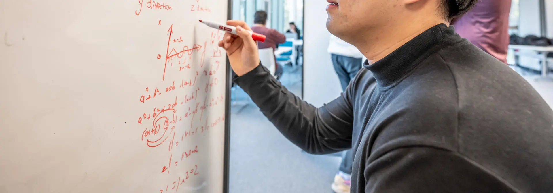 Student working on a maths problem on a whiteboard