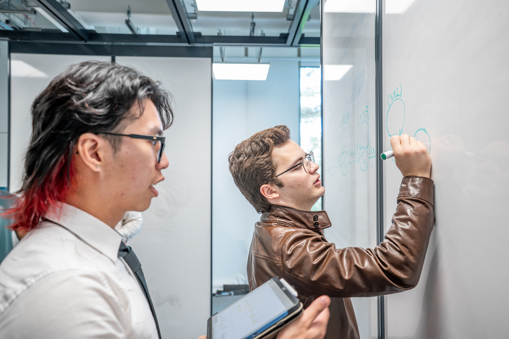 Students working on a problem on a whiteboard