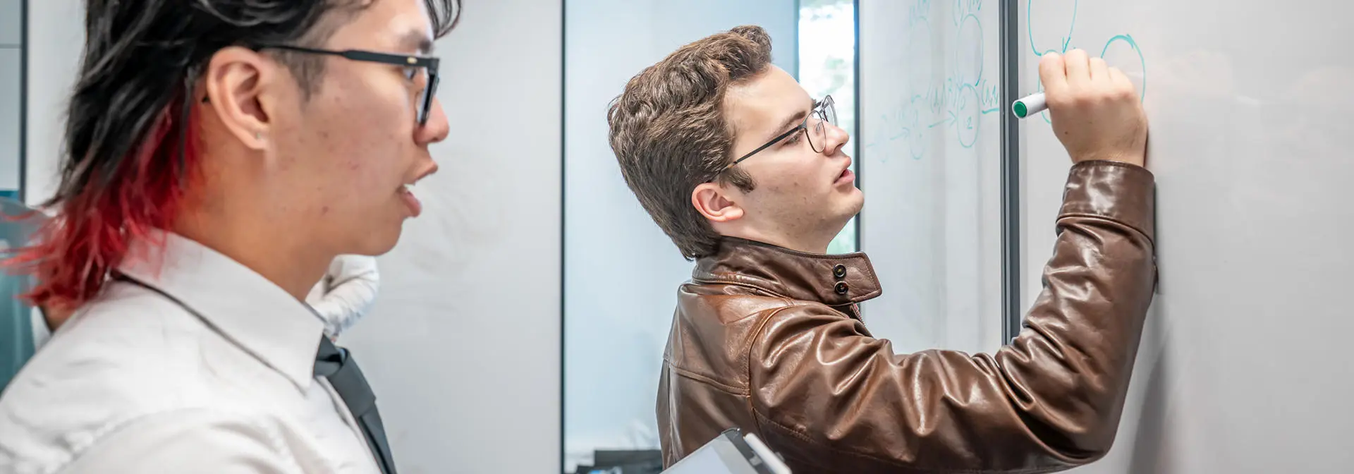 Students working on a problem on a whiteboard