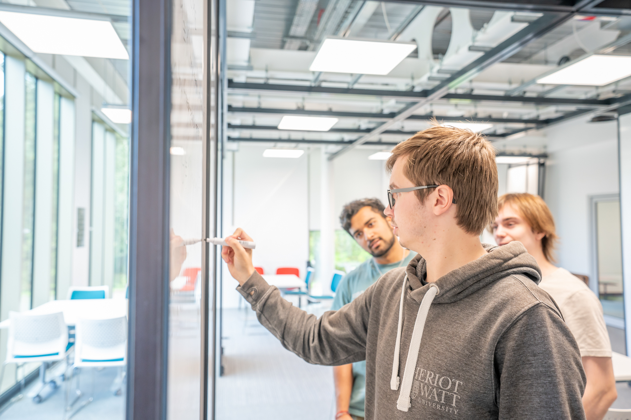 Students working on a question and writing on a whiteboard