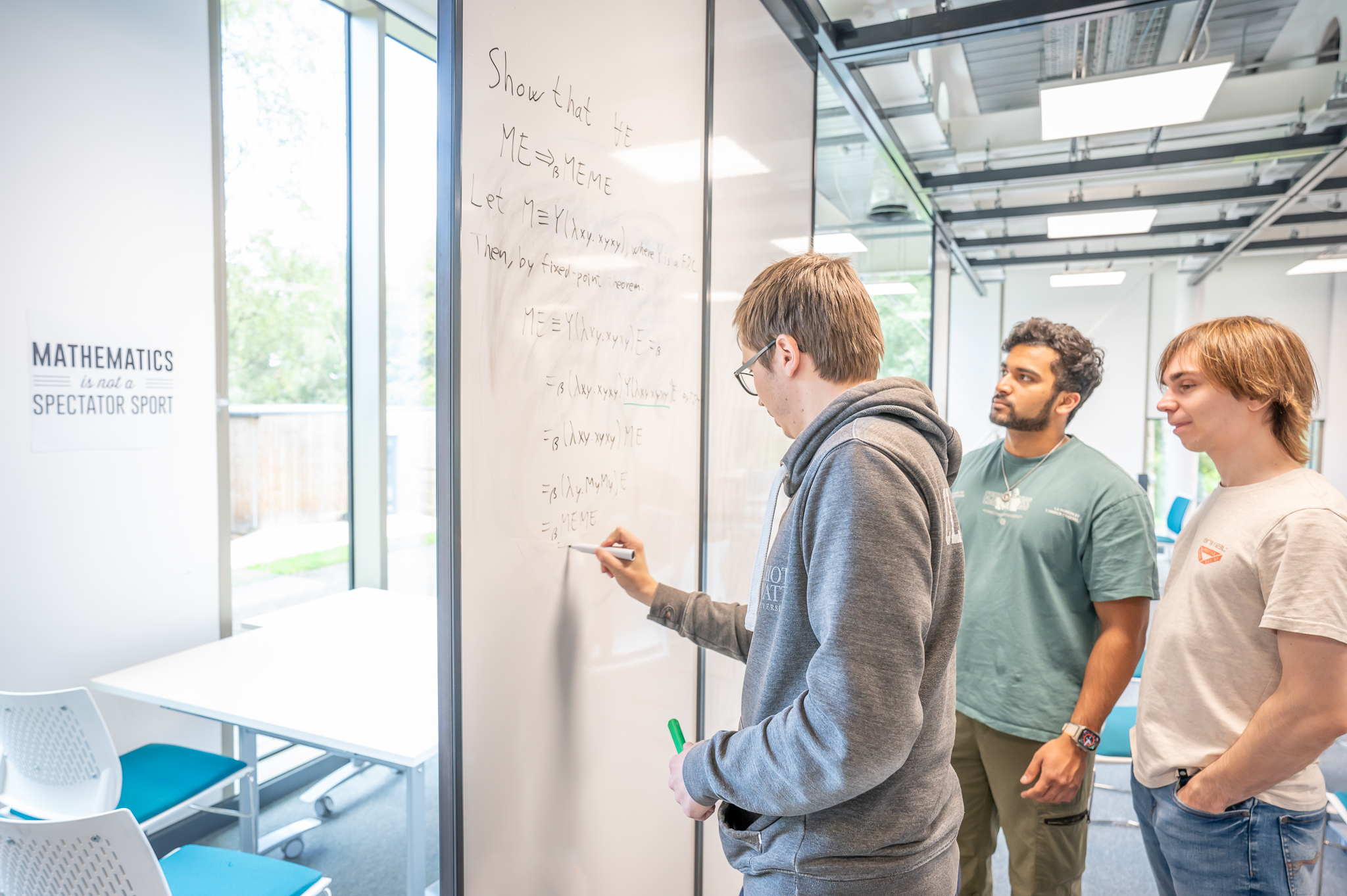 Students working on a math problem together on a whiteboard