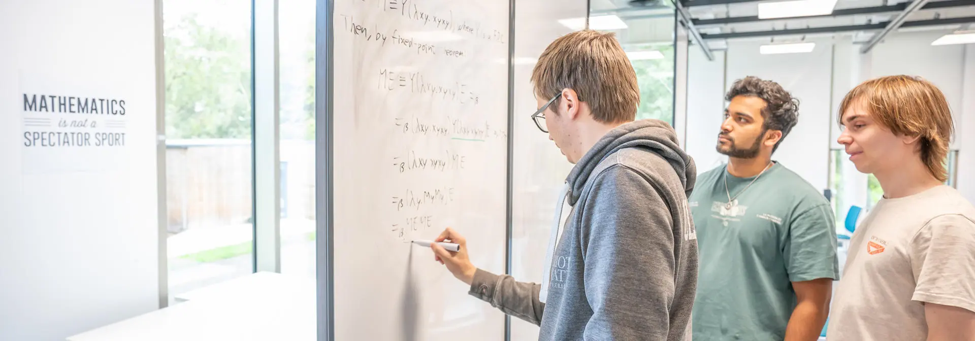 Students working on a math problem together on a whiteboard