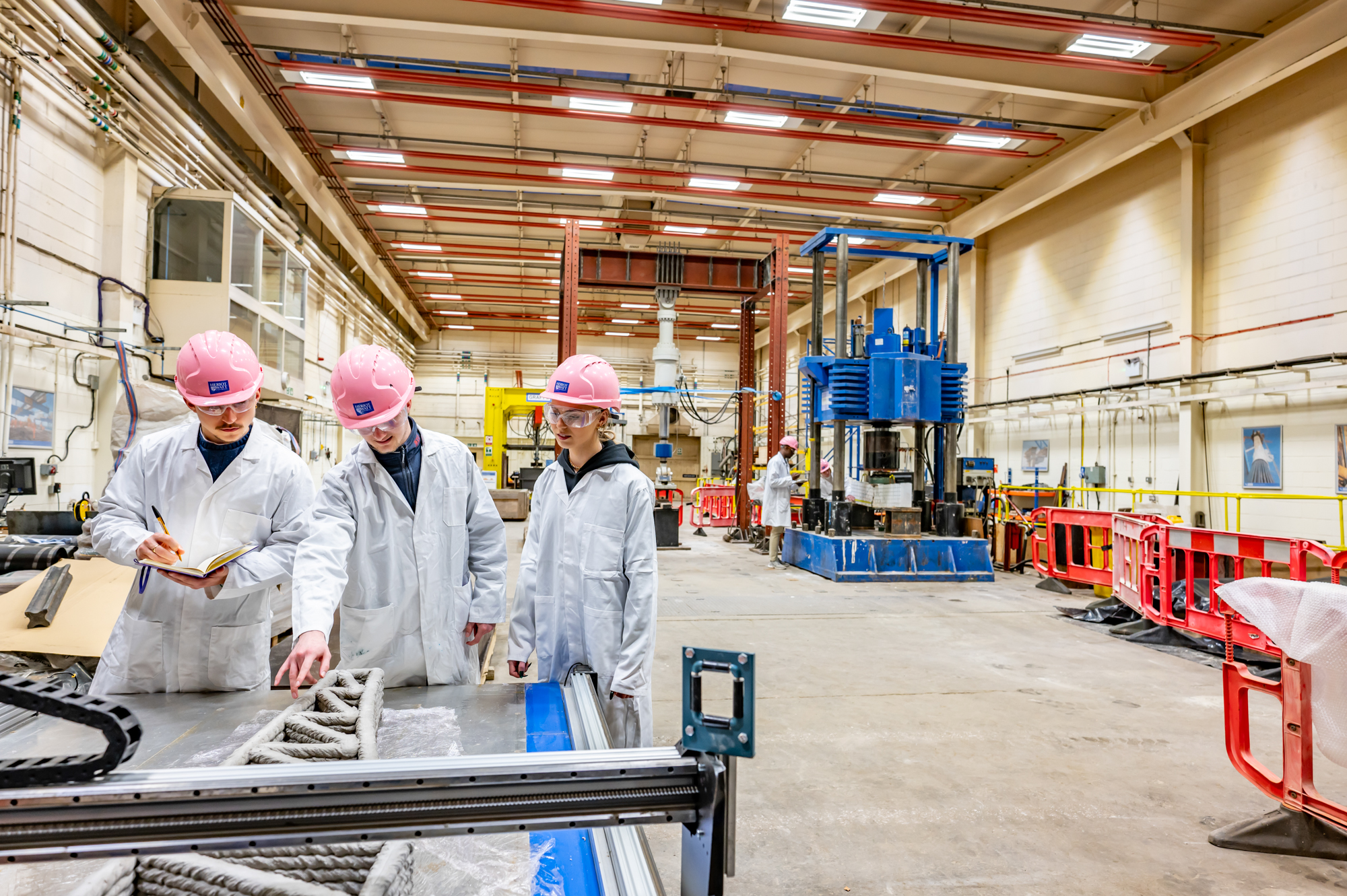 Students with hard helmets working in a lab