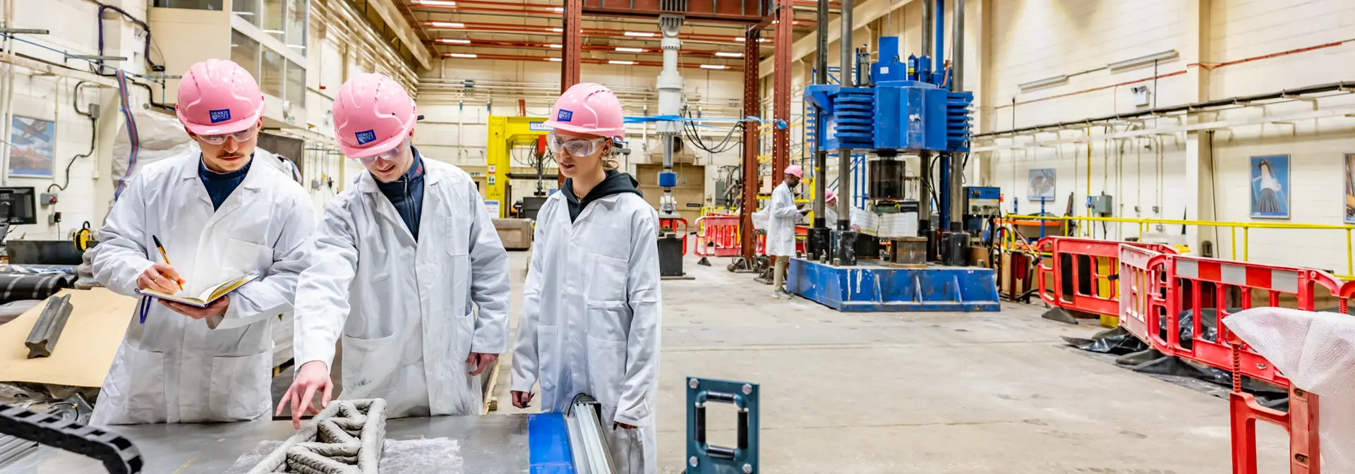 Students with hard helmets working in a lab