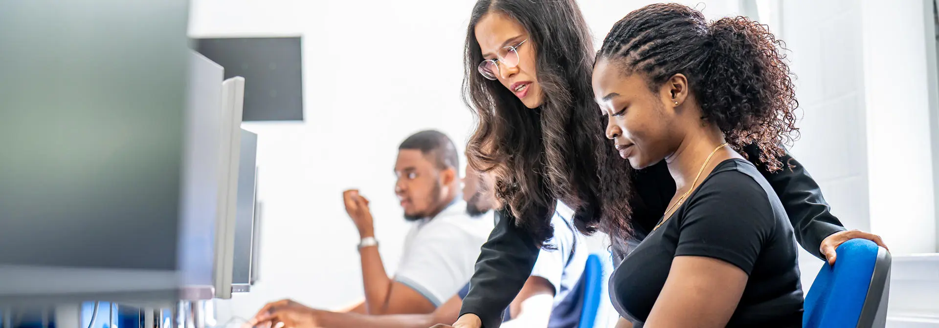 Students working with a professor in a finance lab