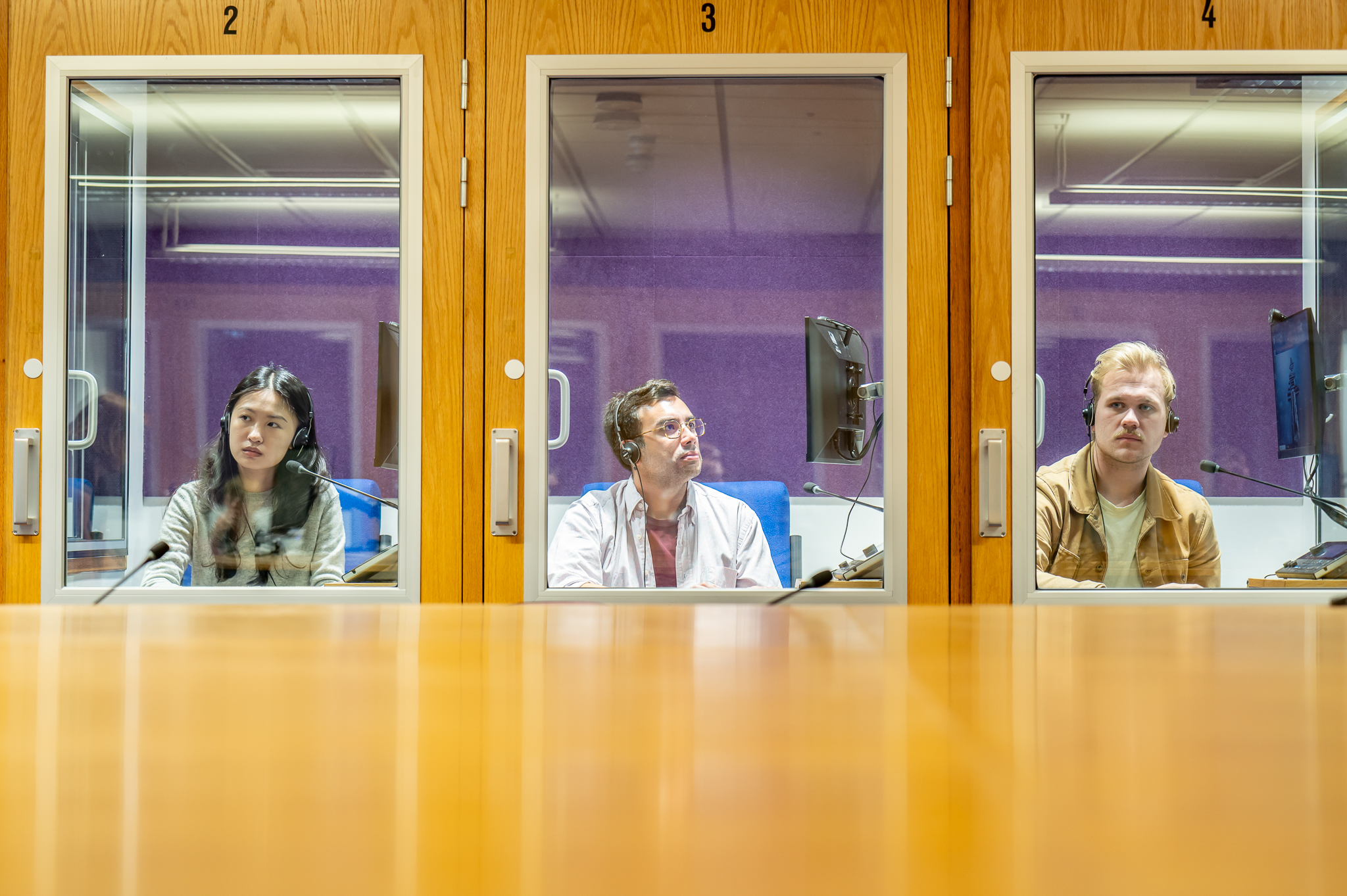Three students in interpreting booths