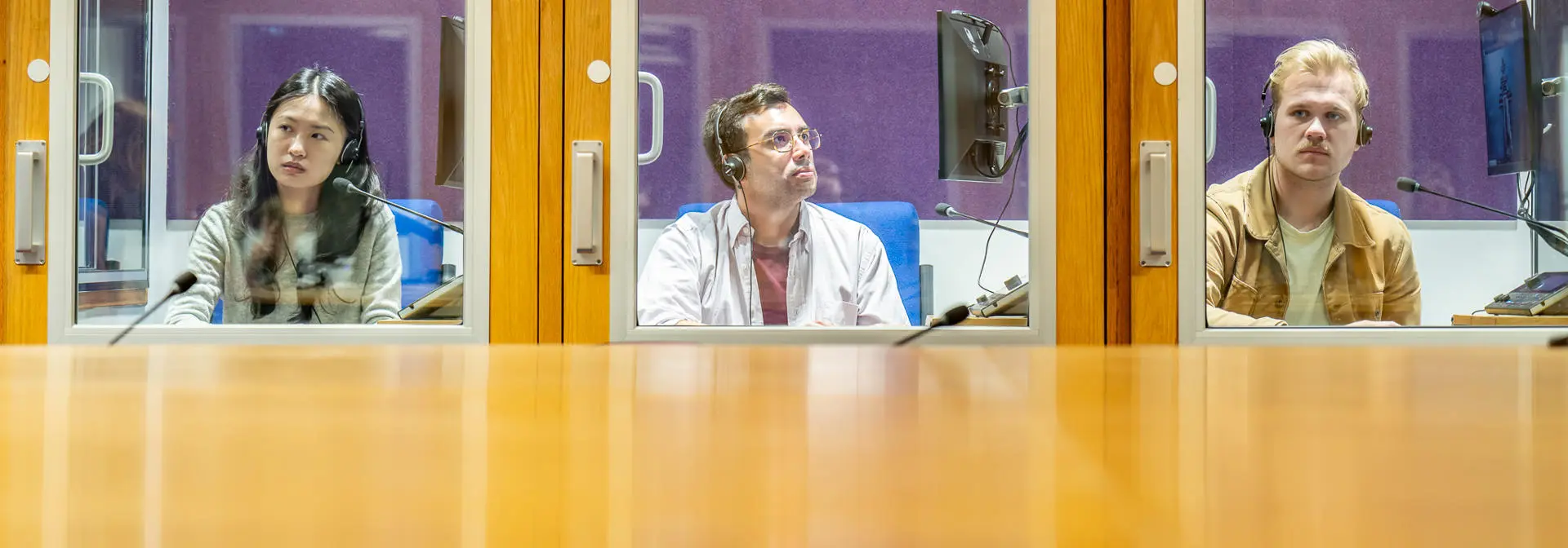 Three students in interpreting booths