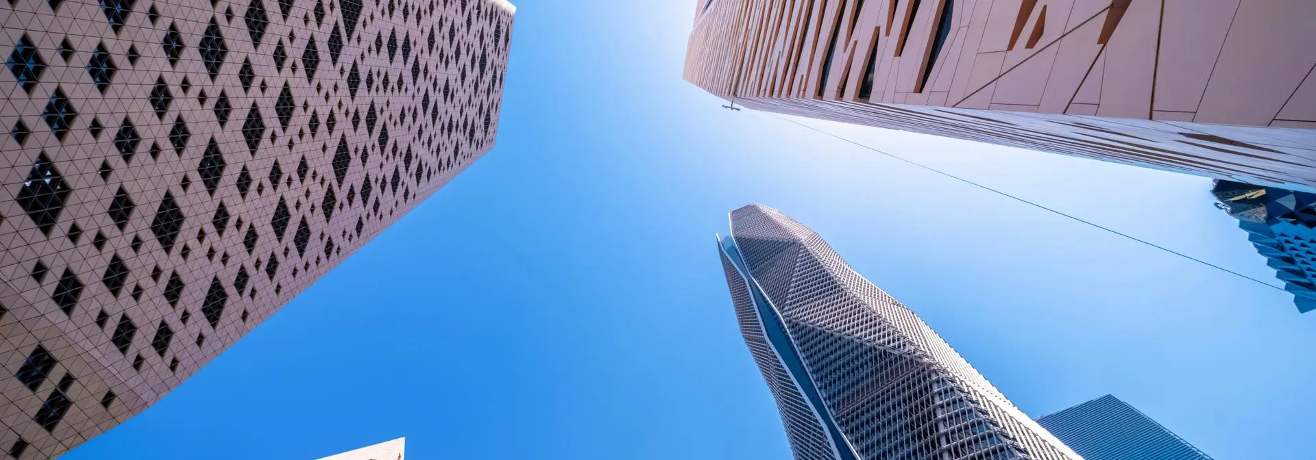 Upward view of several modern skyscrapers converging toward the sky