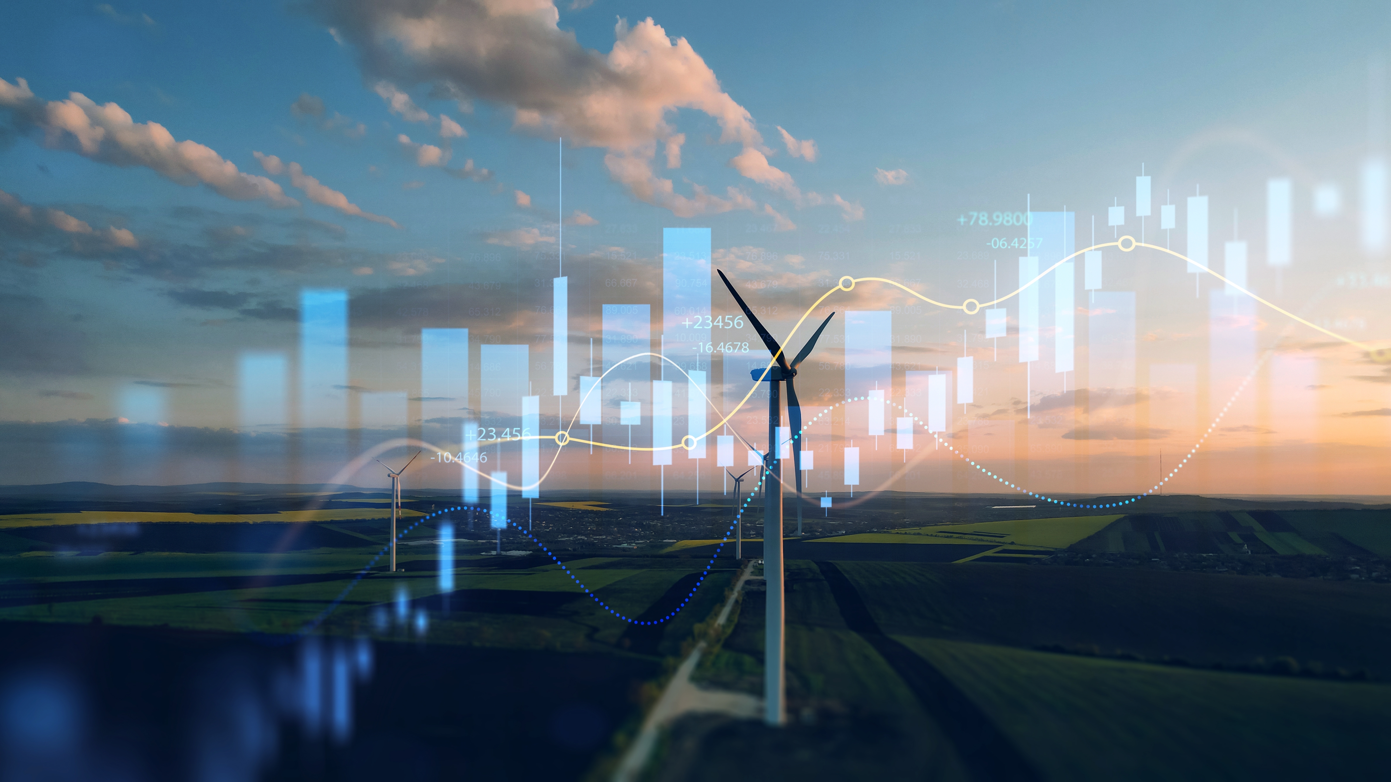 aerial angle of windmill infront of a sunset with overlay of candle chart
