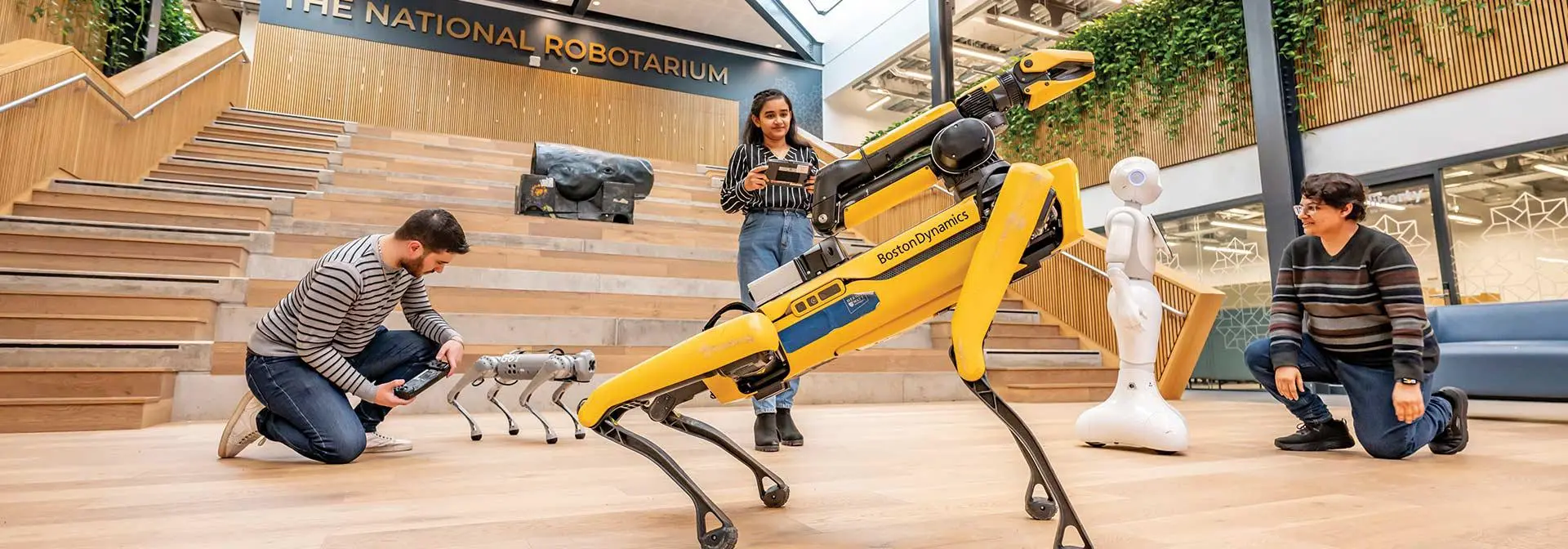 A group of sytudents attentively observing robots in front of them.