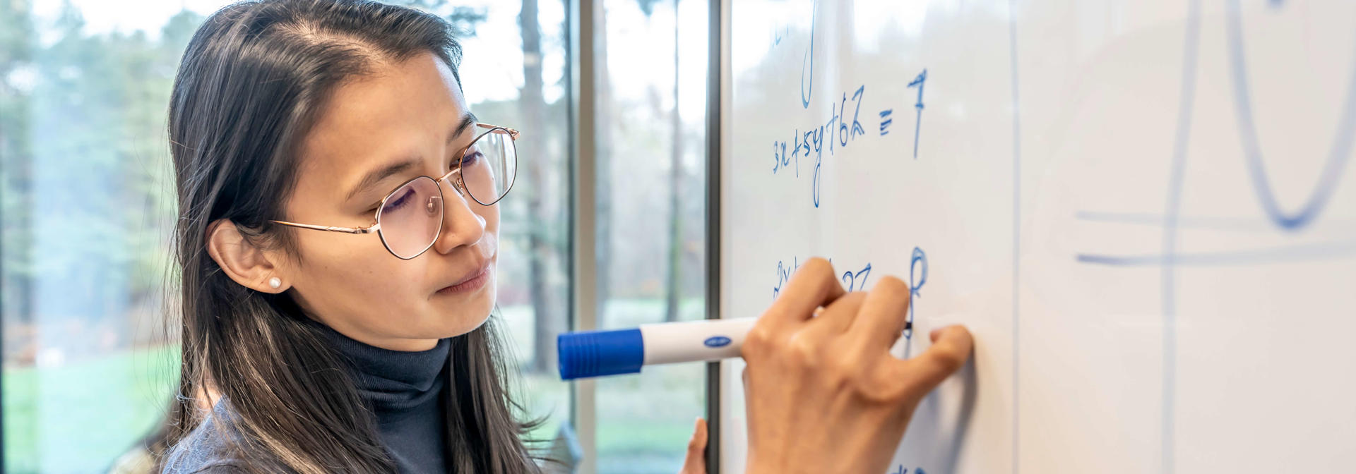 Student solving equation on a whiteboard