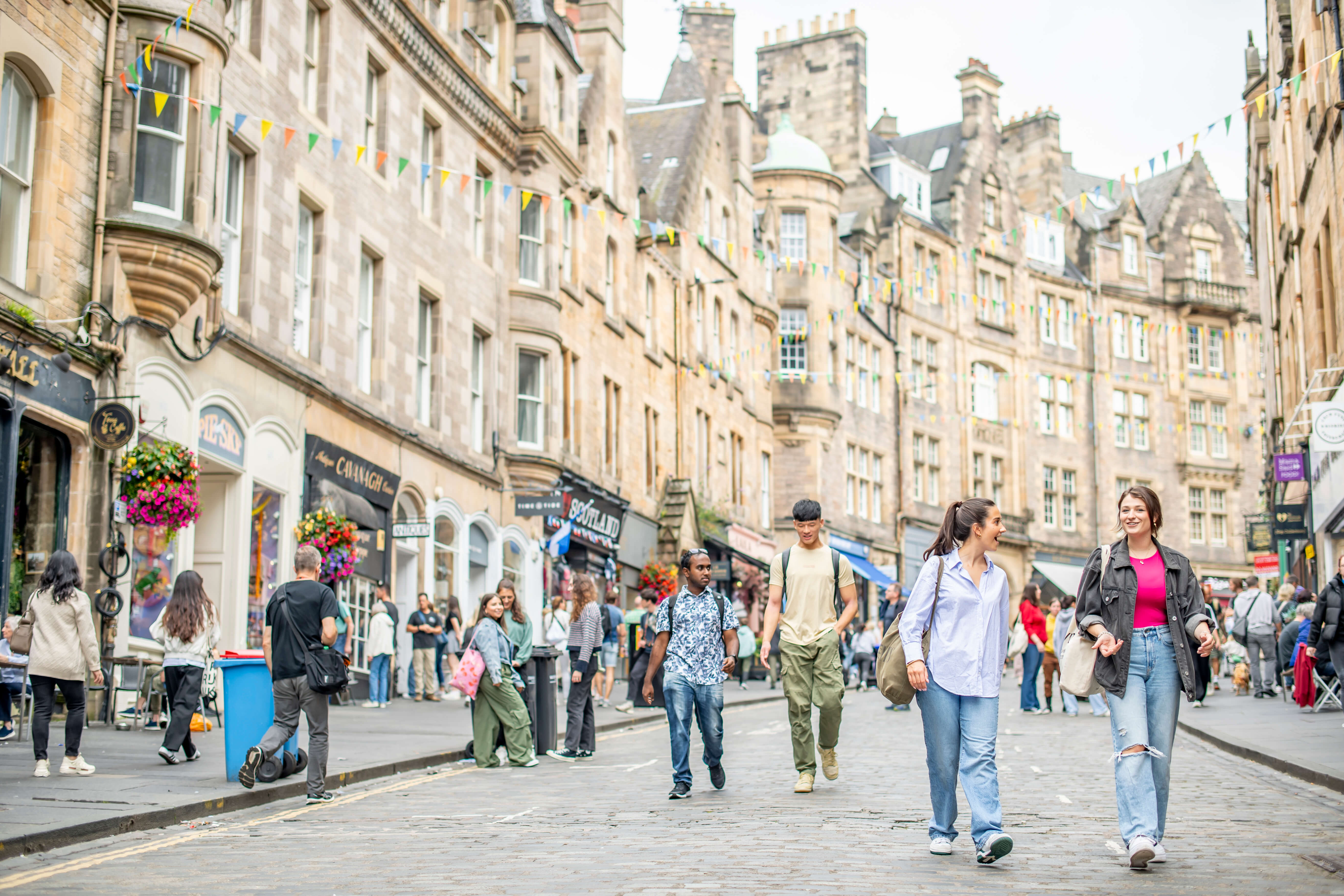 Many people walking together through Victoria Street in Edinburgh.