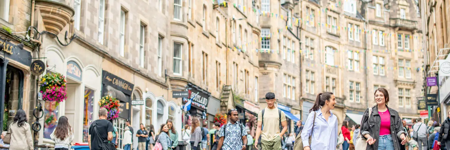 Many people walking together through Victoria Street in Edinburgh.