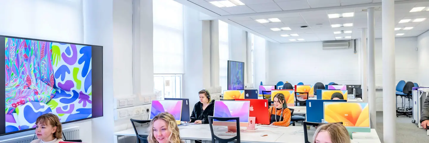A group of students using Macintosh desktop computers